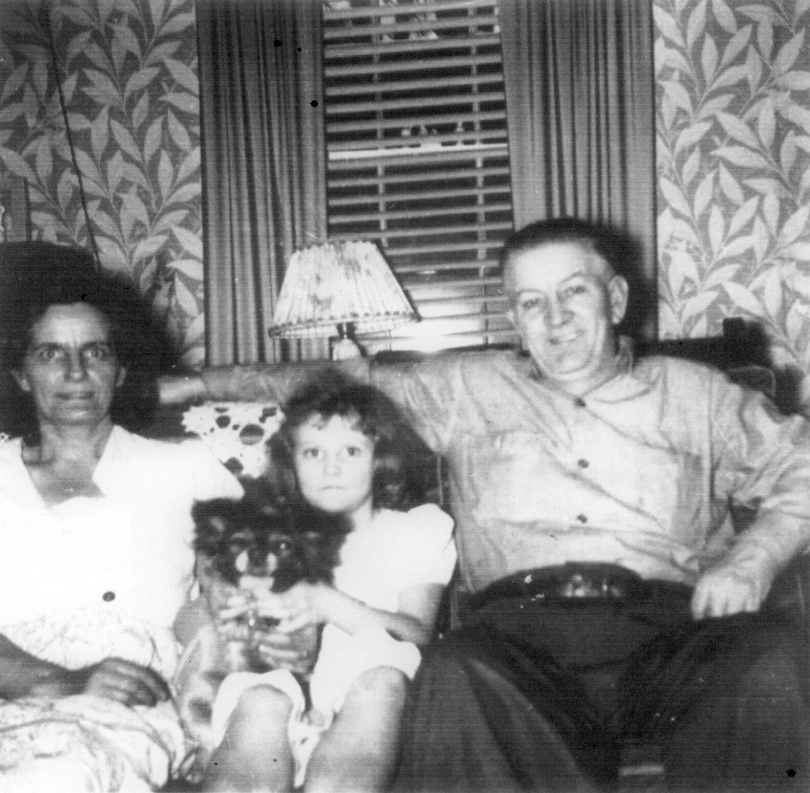 Gilbert Durie on sofa with woman, young girl, and dog